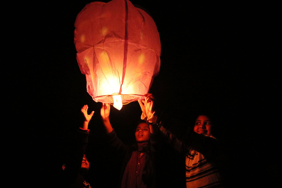 People fly lanterns marking the end of the year 2018 at South Kellaband, Rangpur on 31 December. Photo: Moinul Islam