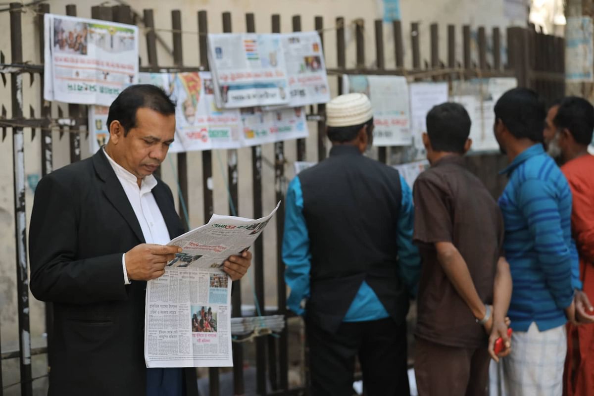 People gathered at newspaper stand as the 11th parliamentary election is over just a day before at Court House Street in Dhaka on 31 December. Photo: Dipu Malakar