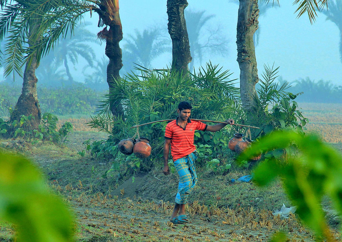 A man setting off for selling date palm juice in the winter morning on 1 January at Kashimpur, Jashore. Photo: Ehsan-Ud-Doula