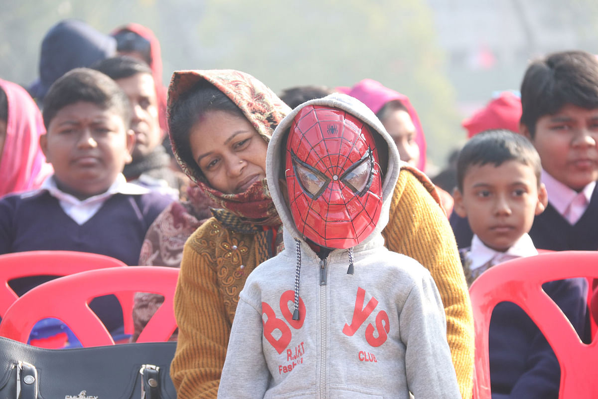 A child wearing a mask attends school with his mother during the textbook festival held across the country on 1 January. Khulna Zila School, Khulna. Photo: Saddam Hossain