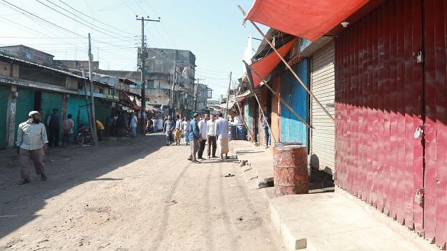Local traders lay a seige to the shop of Sohel at Railway Bazar of Pahartali in Chattogram on Monday. Photo: Jewel Sheel
