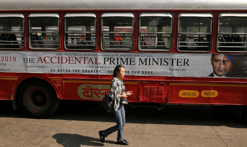 A woman walks past a bus featuring an advertising of the upcoming Bollywood film `The Accidental Prime Minister` in Mumbai, India, 5 January 2019. Photo: Reuters