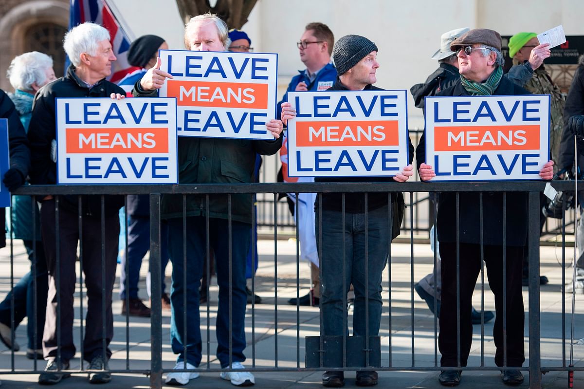 Activists hold up placards from the Leave Means Leave Pro-Brexit campaign group outside the Houses of Parliament in London on 8 Janaury 2019. Photo: AFP