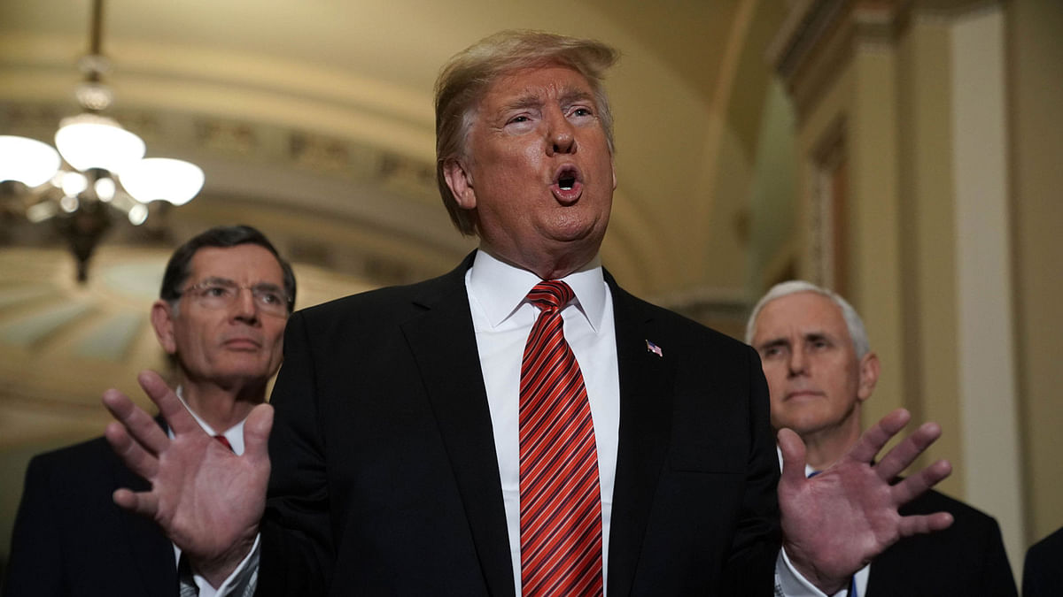 US president Donald Trump (2nd L) speaks to members of the media as Sen. John Barrasso (R-WY) (L) and vice president Mike Pence (R) listen at the US Capitol after the weekly Republican Senate policy luncheon 9 January 2019 in Washington, DC. Photo: Reuters