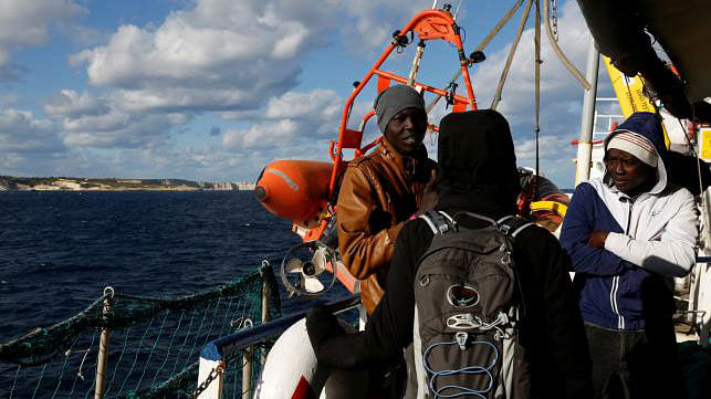 A journalist talks with migrants on the migrant search and rescue ship Sea-Watch 3, operated by German NGO Sea-Watch, off the coast of Malta in the central Mediterranean Sea, on 4 January, 2019. Photo: Reuters