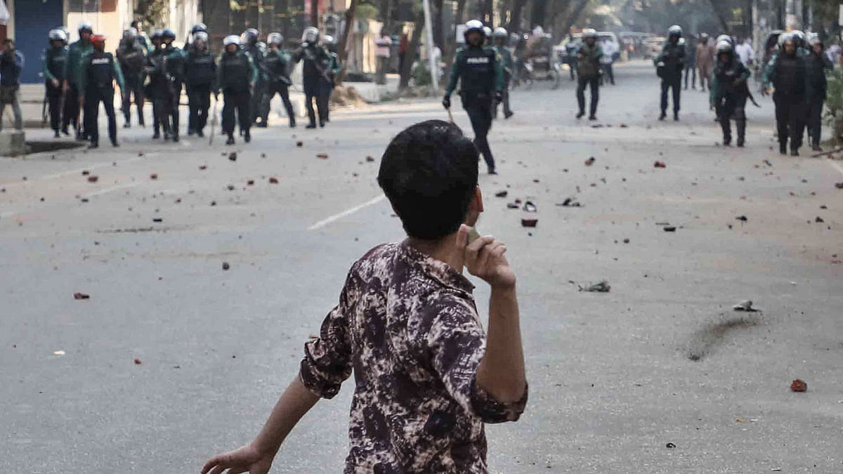 In this file photo taken on 8 January 2019 a man throws a stone towards police during clashes as Bangladeshi striking garments workers march in the streets to demand wage hikes in Dhaka. AFP File Photo