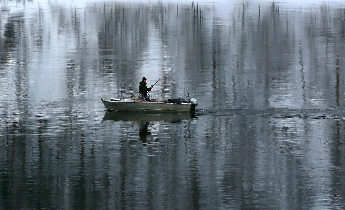 A man fishes on the Yenisei river in the Siberian taiga area outside Krasnoyarsk, Russia on 9 January 2019. Photo: Reuters