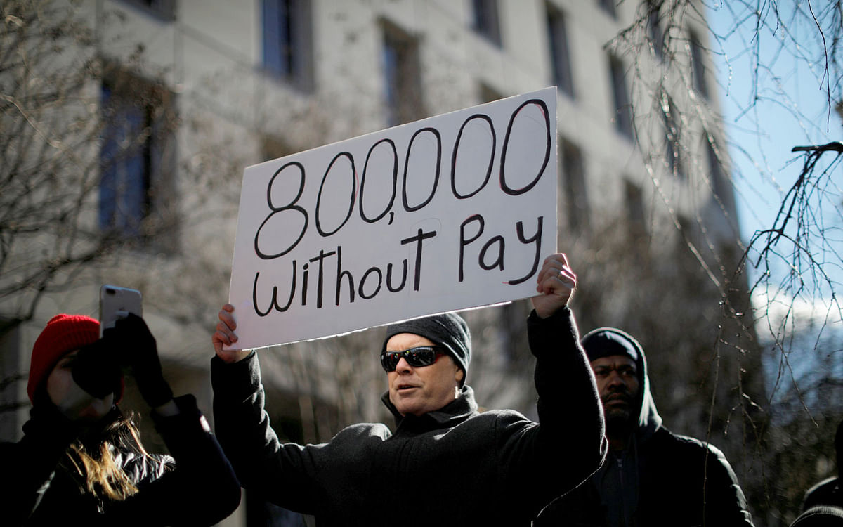 A demonstrator holds a sign, signifying hundreds of thousands of federal employees who won’t be receiving their paychecks as a result of the partial government shutdown, during a “Rally to End the Shutdown” in Washington, US on 10 January, 2019. Photo: Reuters