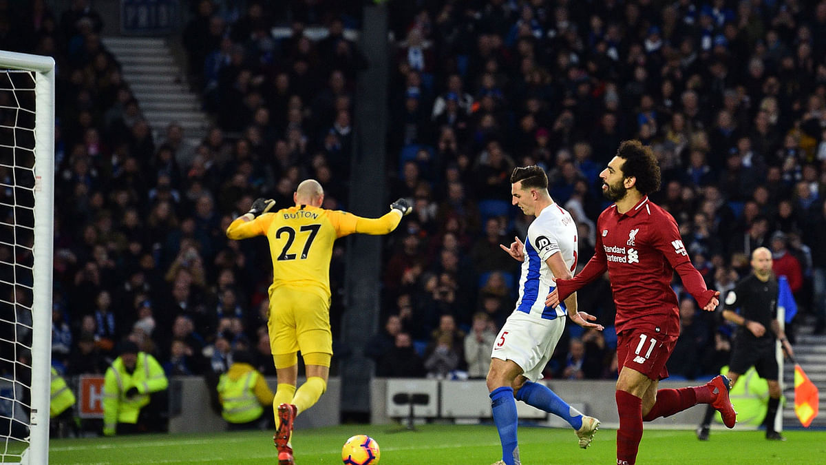 Liverpool`s Egyptian midfielder Mohamed Salah (R) celebrates after scoring the opening goal from the penalty spot during the English Premier League football match between Brighton and Hove Albion and Liverpool at the American Express Community Stadium in Brighton, southern England on 12 January, 2019. Photo: AFP