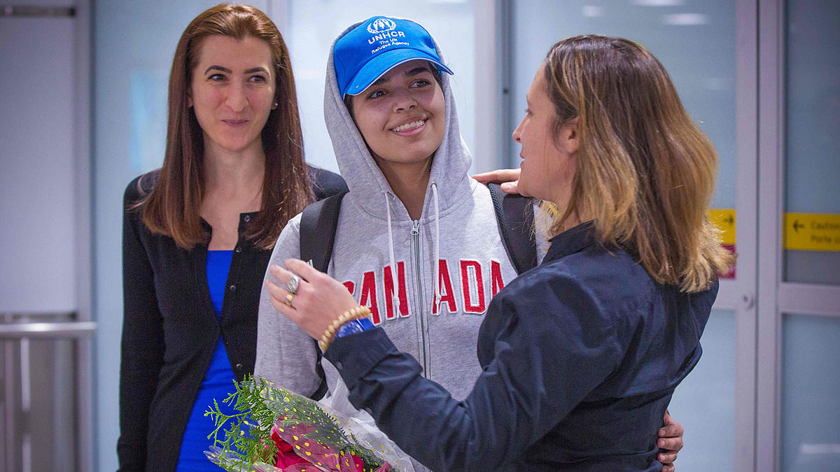 Saudi teenager Rahaf Mohammed al-Qunun (C, blue cap) is welcomed by Canadian minister for foreign affairs Chrystia Freeland (R) as she arrives at Pearson International airport in Toronto, Ontario, on 12 January, 2019. Photo: AFP