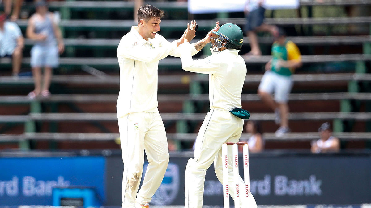 South African bowler Duanne Olivier (L) celebrates with teammate during the second day of the third Cricket Test match between South Africa and Pakistan at Wanderers cricket stadium on 12 January, 2019 in Johannesburg, South Africa. Photo: AFP