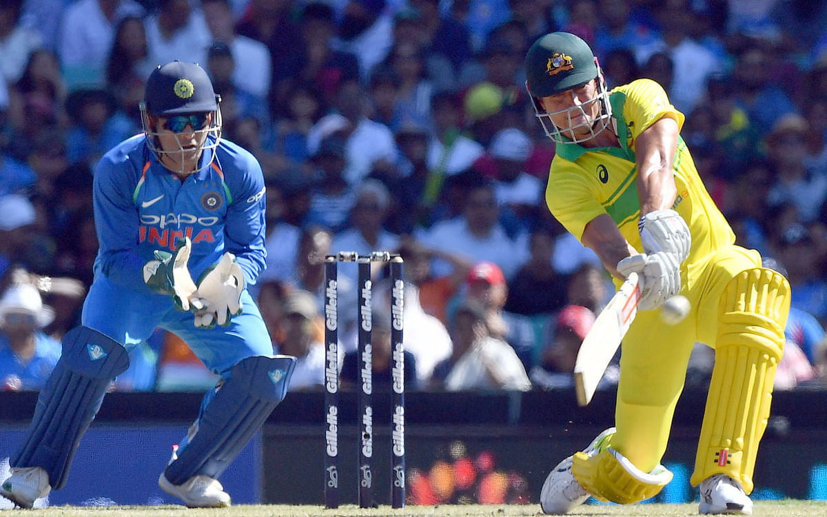 Australia’s Peter Handscomb plays a shot over the boundary line for six runs as India’s wicketkeeper Mahendra Singh Dhoni (L) looks on during the first one-day International (ODI) match between Australia and India at the Sydney Cricket Ground in Sydney on 12 January 2019. Photo: AFP