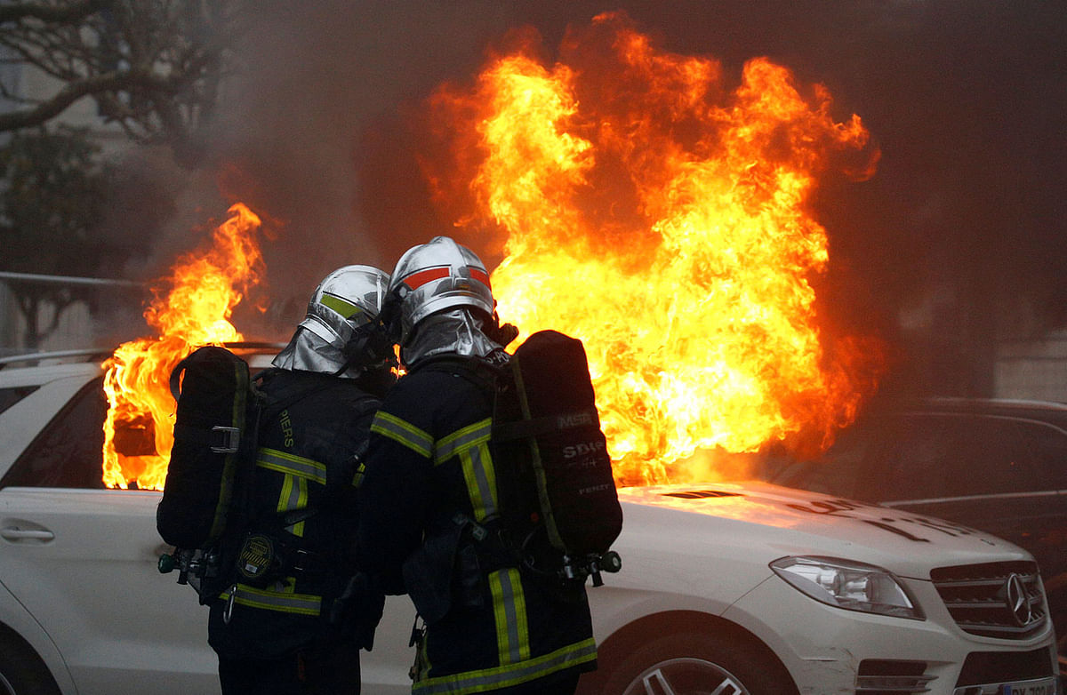 Firefighters try to extinguish a burning car during a demonstration of the `yellow vests` movement in Nantes, France, on 12 January 2019. Photo: Reuters