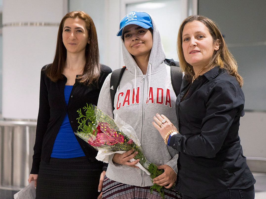 Rahaf Mohammed Alqunun, 18, center, stands with Canadian Minister of Foreign Affairs Chrystia Freeland, right, as she arrives at Toronto Pearson International Airport, on Saturday, 12 January 2019. Photo: AP