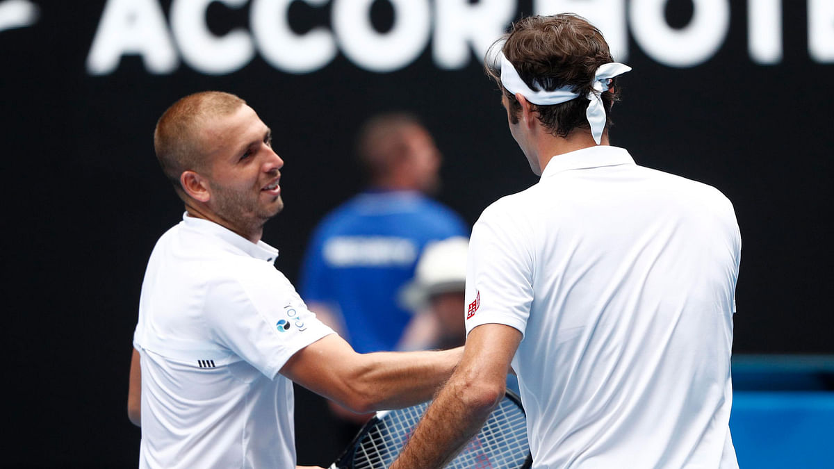 Roger Federer shakes hands with Dan Evans after the match. Photo: Reuters