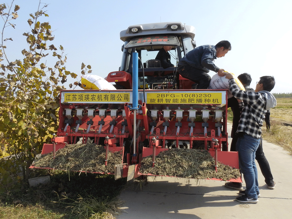 Staff members taking part in the experiment on automated farming machinery load fertilizer onto an automated tractor near a field in Xinghua, Jiangsu province, China on 30 October 2018. Photo: Reuters