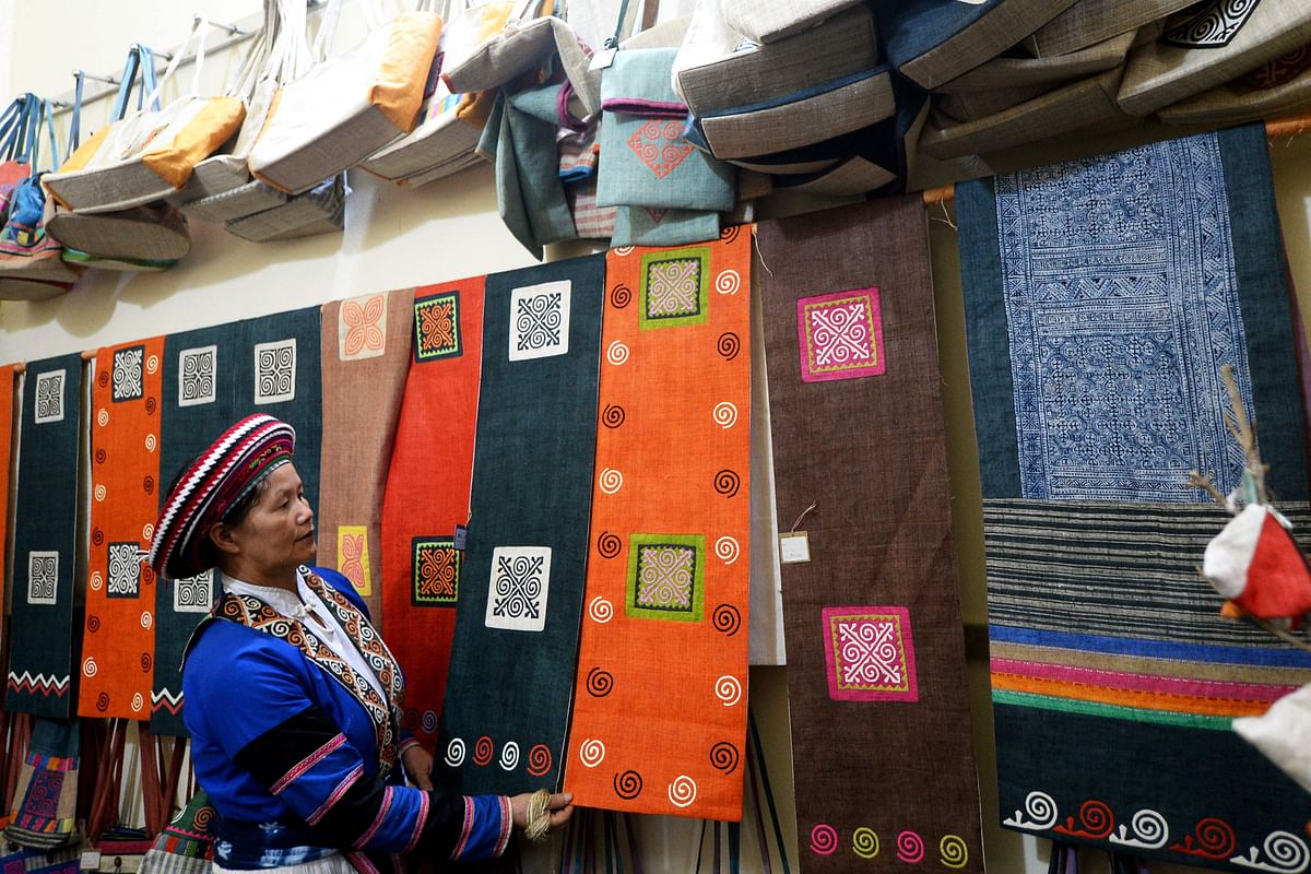 This picture taken on 29 October 2018 shows ethnic Hmong woman Vang Thi Mai arranging traditional table runners at the Lung Tam Linen cooperative in northern Vietnam`s Quan Ba district. Photo: AFP