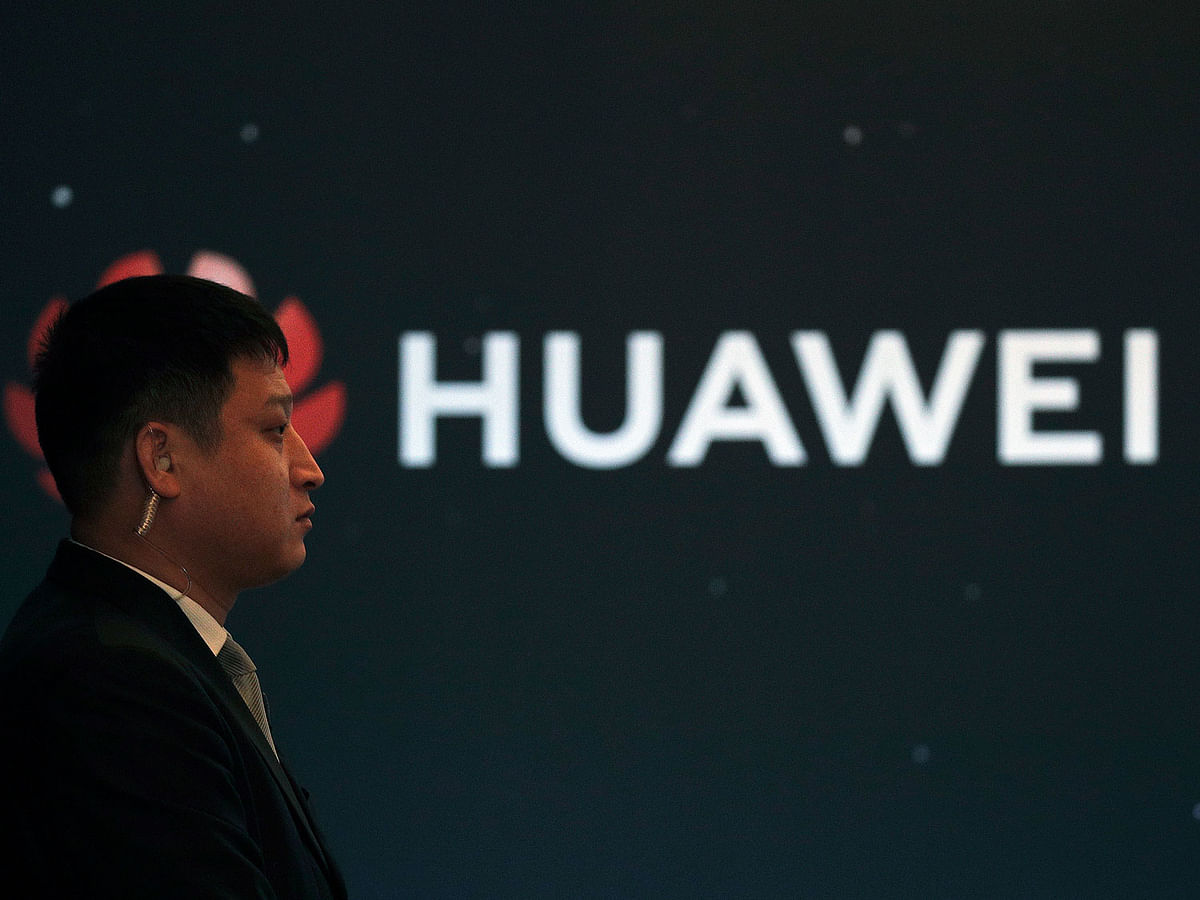In this 9 January 2019, photo, a security guard stands near the Huawei company logo during a new product launching event in Beijing. Photo: AP