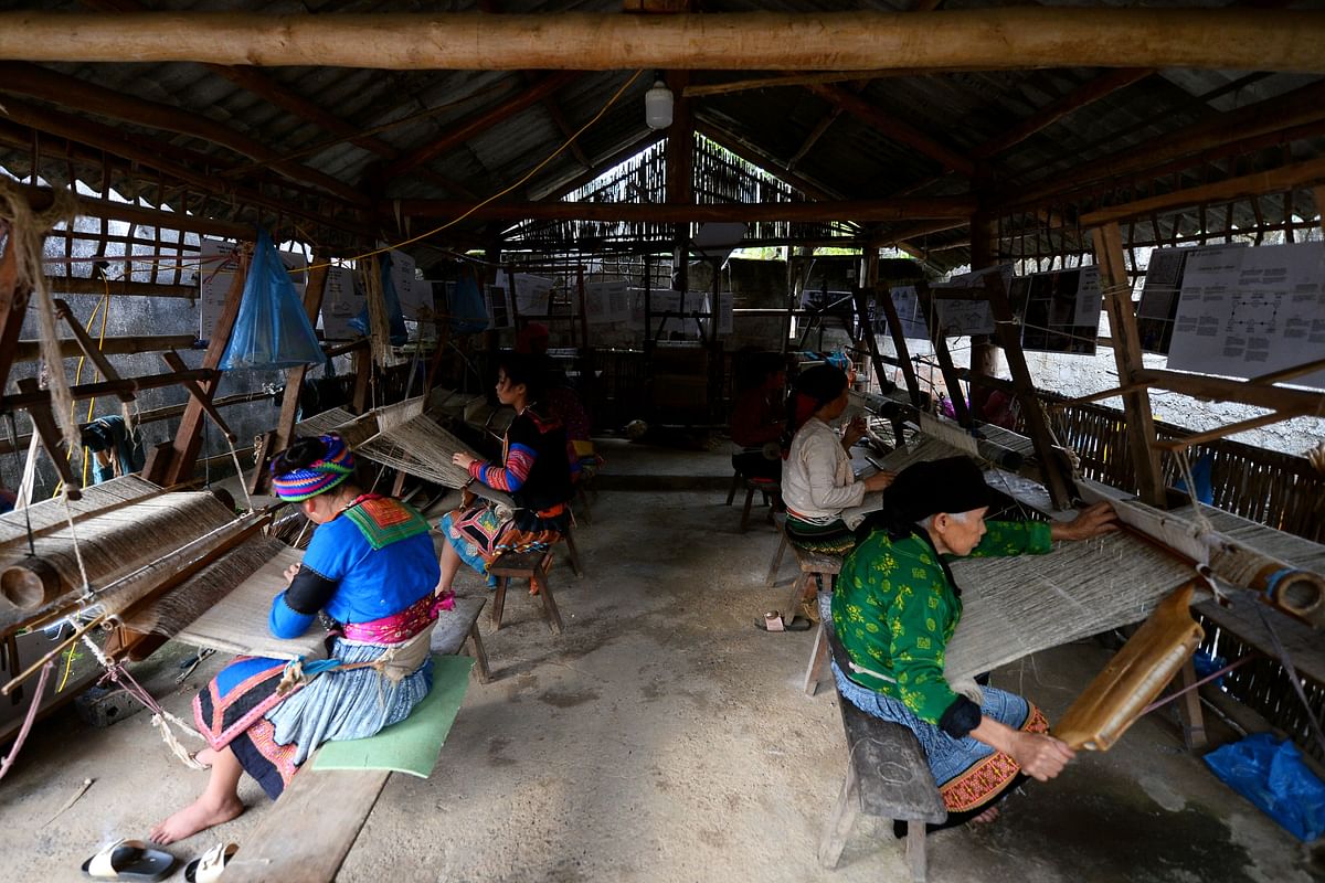 This picture taken on 29 October 2018 shows ethnic Hmong women weaving traditional textiles at the Lung Tam Linen cooperative in northern Vietnam`s Quan Ba district. Photo: AFP