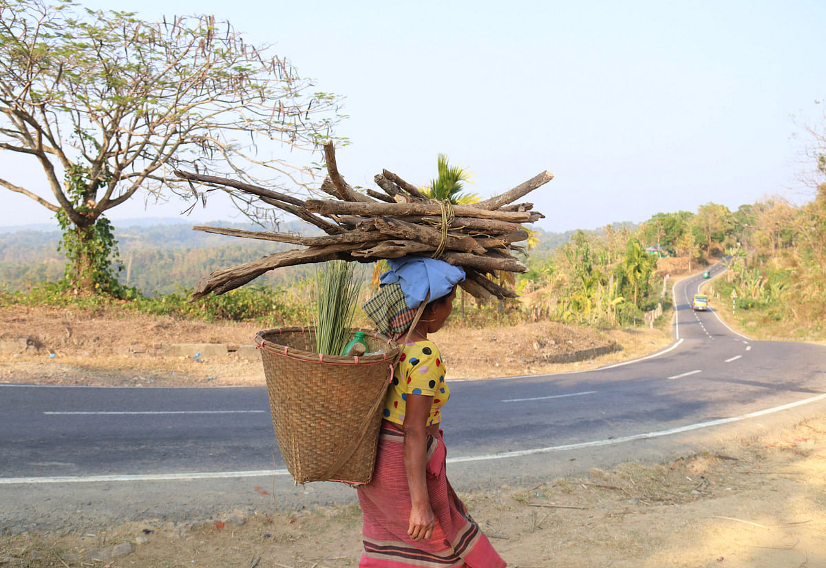 An ethnic Tripura woman is seen returning home with biomass fuels after cultivating in the hills of Hridoy Memberpara in Matiranga of Khagrachhari, on 16 January. Photo: Nirob Chowdhury