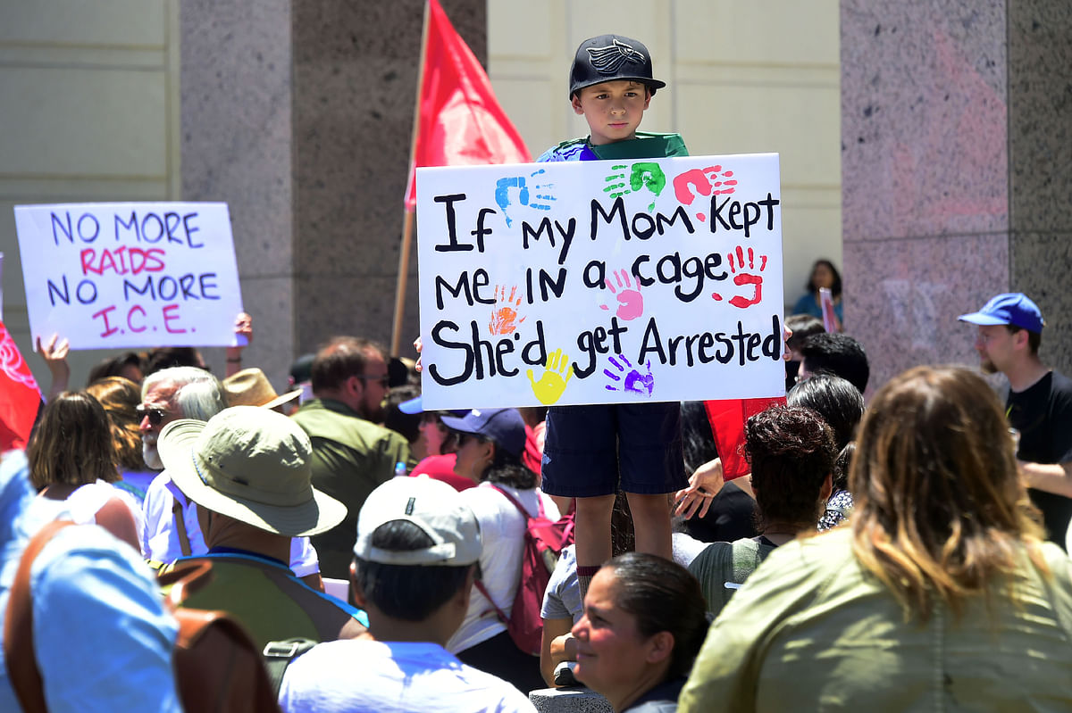 In this file photo taken on 30 June 2018 people hold placards during a `Families Belong Together` march and rally in Los Angeles, California where a thousands turned out to decry the Trump administration`s detention of families policy at the US Mexico border. Photo: AFP