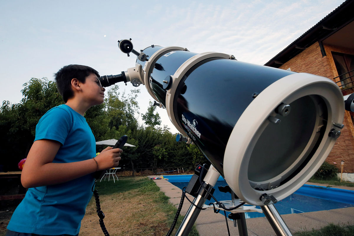 Ricardo Barriga, 10, observes the moon with his telescope in his home in Pirque, Chile on 16 January 2019. Photo: Reuters