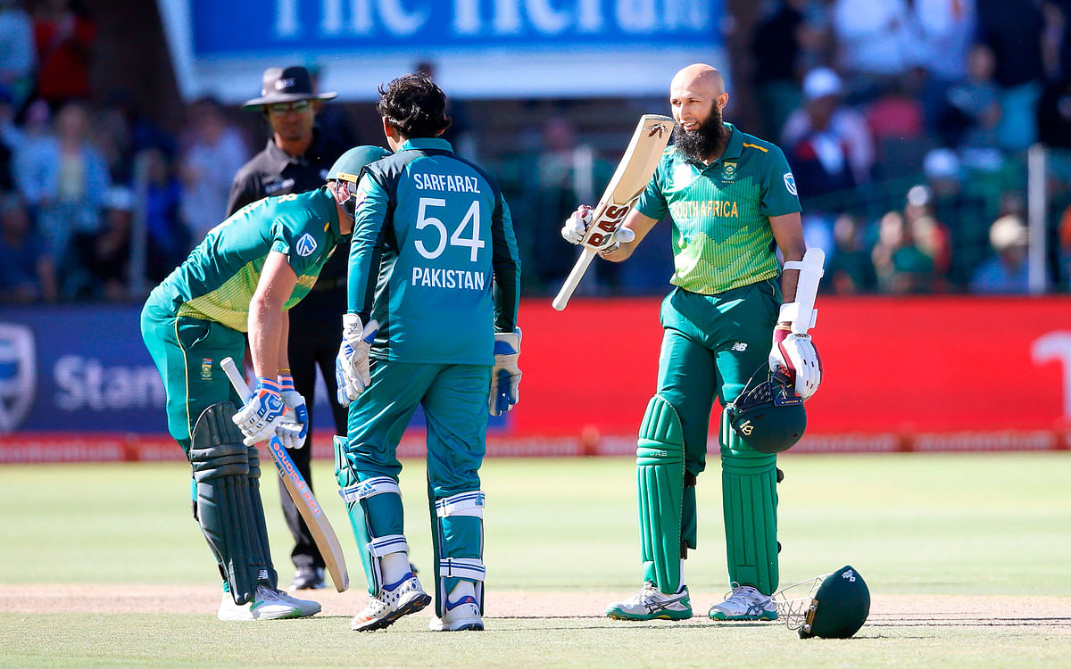 South African batsman Hashim Amla (R) raises his bat as he celebrates scoring a century (100 runs) during the first One Day International (ODI) match between South Africa and Pakistan at St. George`s cricket stadium on 19 January, 2019 in Port Elizabeth, South Africa. Photo: AFP