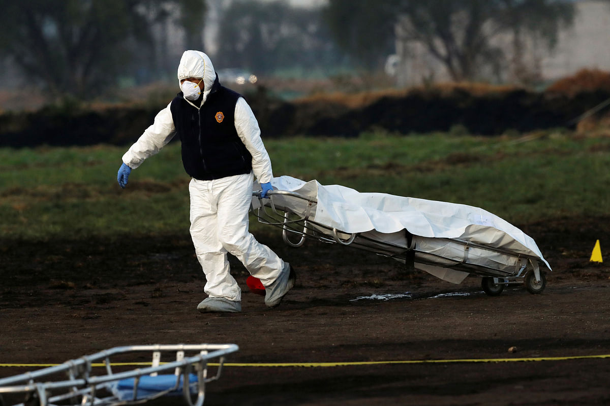 A forensic technician removes a body from the site where a fuel pipeline ruptured by suspected oil thieves exploded, in the municipality of Tlahuelilpan, state of Hidalgo, Mexico 19 January, 2019. Photo: Reuters
