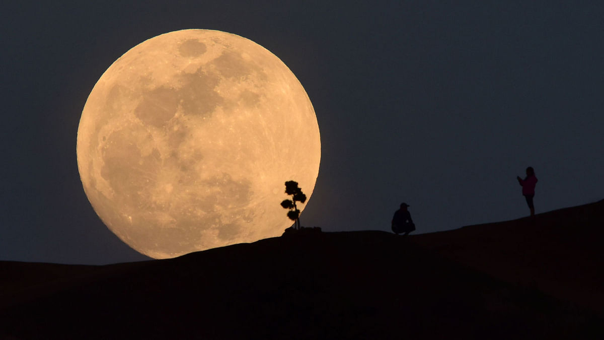 In this file photo taken on 30 January 2018, a person poses for a photo as the moon rises over Griffith Park in Los Angeles, California. AFP File Photo