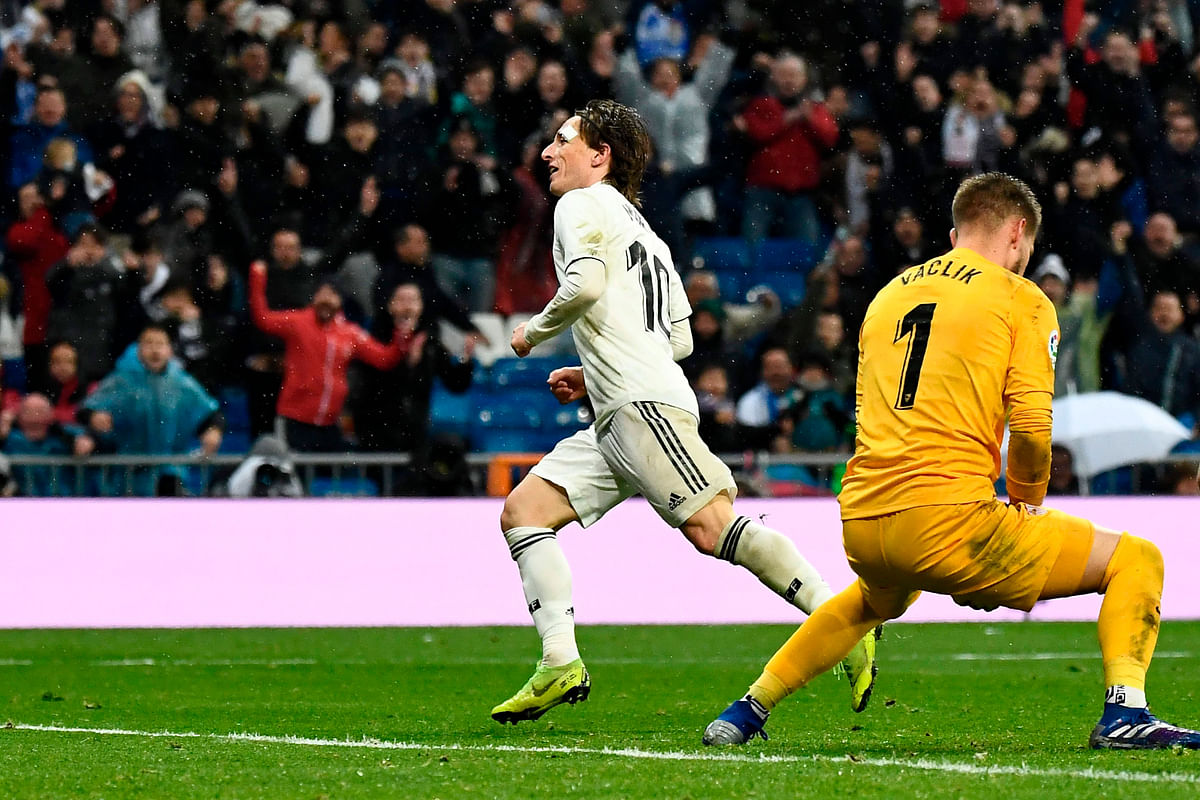 Real Madrid`s Croatian midfielder Luka Modric (L) celebrates after scoring against Sevilla`s Czech goalkeeper Tomas Vaclik (R) during the Spanish League football match between Real Madrid and Sevilla at the Santiago Bernabeu stadium in Madrid on 19 January 2019. Photo: AFP