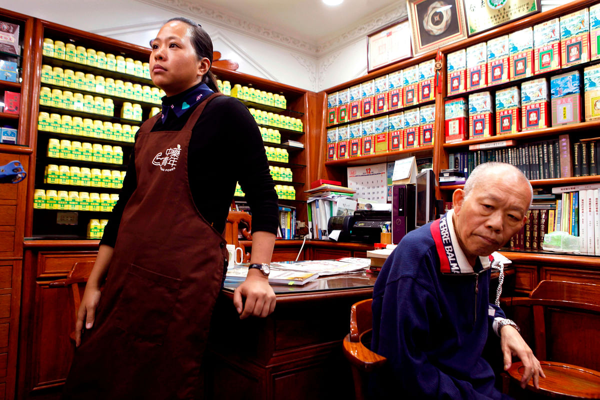 This photo taken on 18 December 2018 shows traditional medicine store owner Gu Cheng-pu (L) and her father-in-law Hsu Ping-jen (R) at the family`s Chinese herbal medicine store in New Taipei City. Photo: AFP