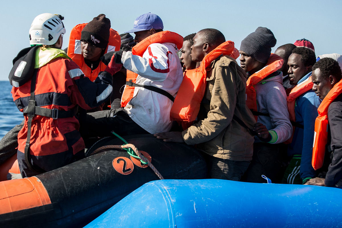 A group of 47 migrants is helped by a Sea Watch 3 crew member (L) during their transfer from a rescued unflatable boat onto a Sea Watch 3 RHIB (Rigid Hull Inflatable Boat) during a rescue operation by the Dutch-flagged vessel Sea Watch 3 off Libya`s coasts on 19 January 2019. Photo: AFP
