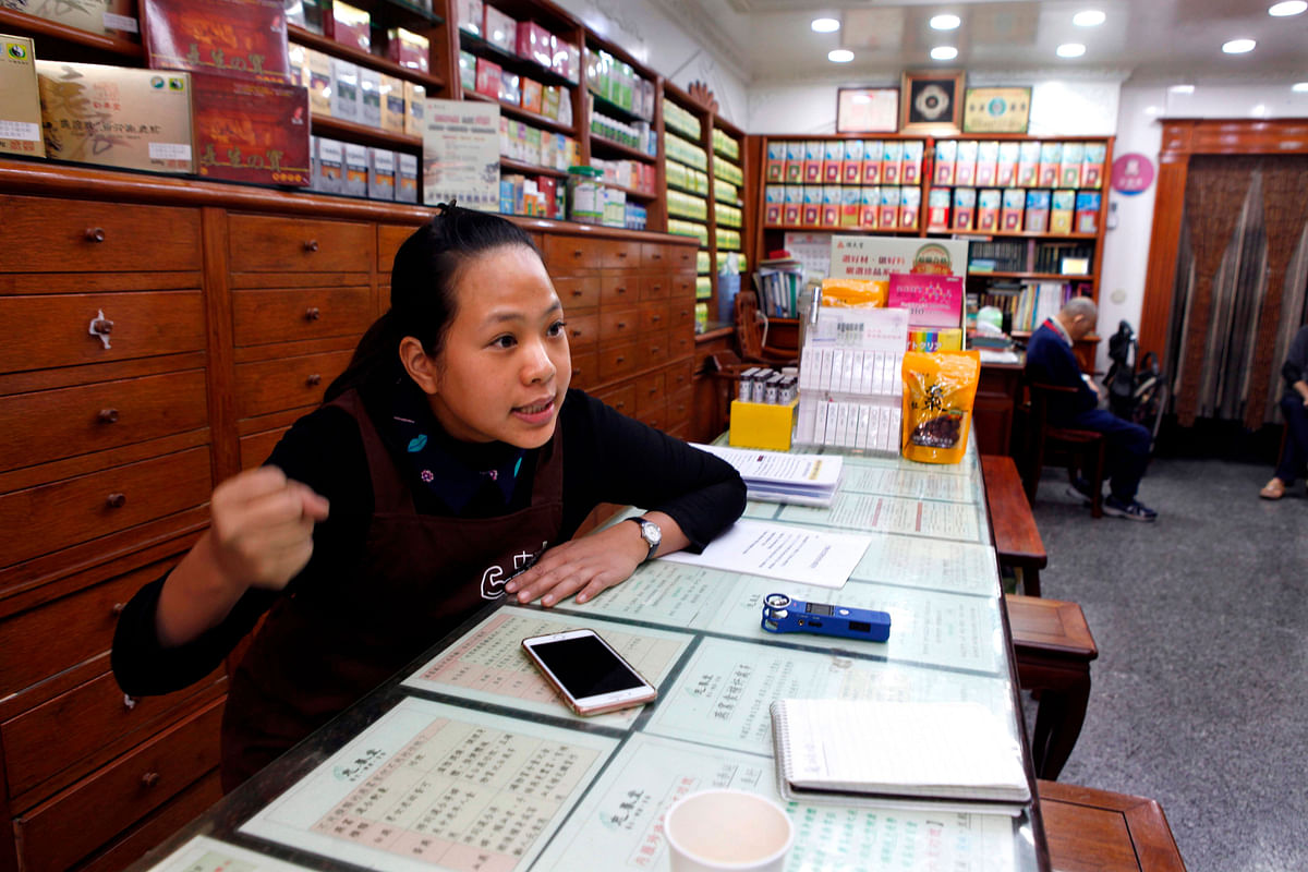 This photo taken on 18 December 2018 shows traditional medicine store owner Gu Cheng-pu behind the counter at the family`s Chinese herbal medicine store in New Taipei City. Photo: AFP