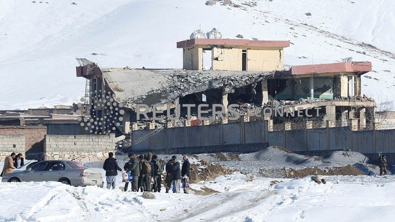 Afghan men stand in front of a collapsed building of a military base after a car bomb attack in Maidan Wardak, Afghanistan, 21 January 2019. Photo: Reuters