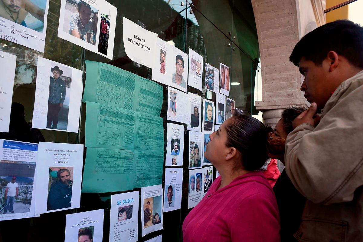 Relatives of people missing after the blaze triggered by a leaky pipeline in Tlahuelilpan, Hidalgo state, Mexico on 20 January, 2019, look for their beloved ones in a list of disappeared people. Photo: AFP