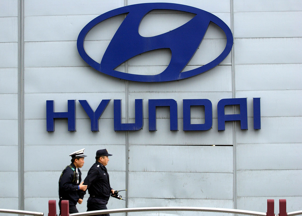 In this file photo taken on 19 April 2006 policemen walk past a logo of Hyundai motor displayed in front of its headquarters in Seoul. Photo: AFP
