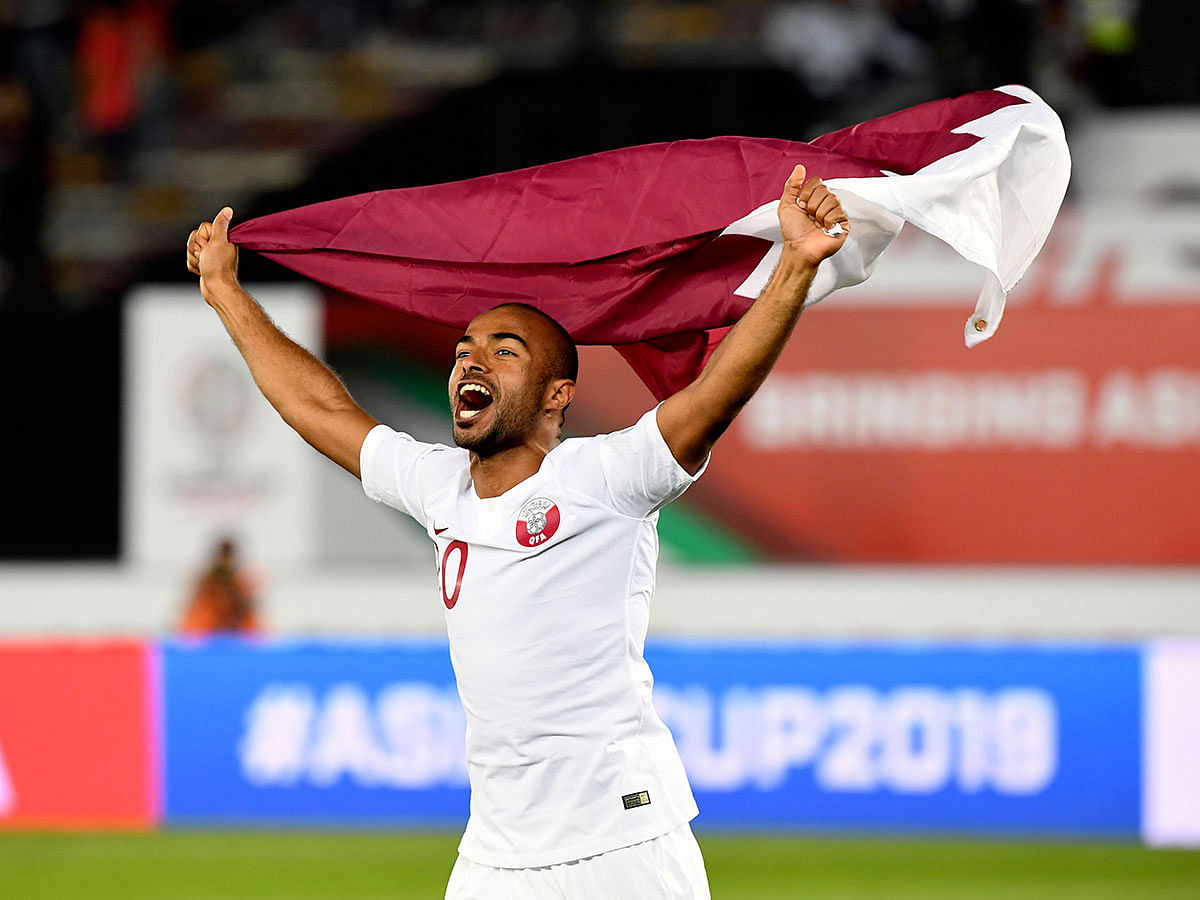 Qatar`s midfielder Ali Yahya celebrates the win with the national flag during the 2019 AFC Asian Cup quarter-final football match between South Korea and Qatar at Zayed Sports City in Abu Dhabi on 25 January, 2019. Photo: AFP