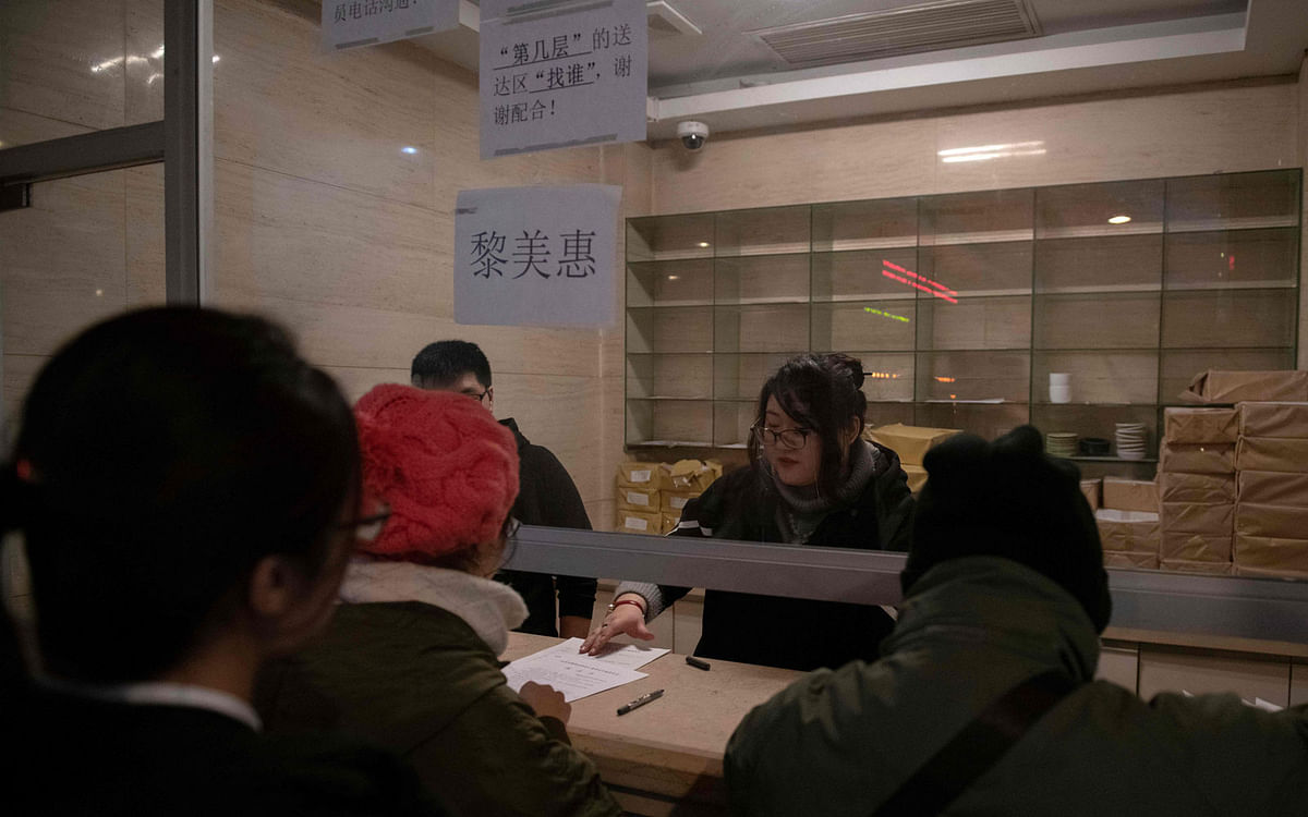 In this picture taken on 23 January 2019 people get forms to fill up by a staff member (C) at the Chaoyang Arbitration Centre in Beijing. Photo: AFP