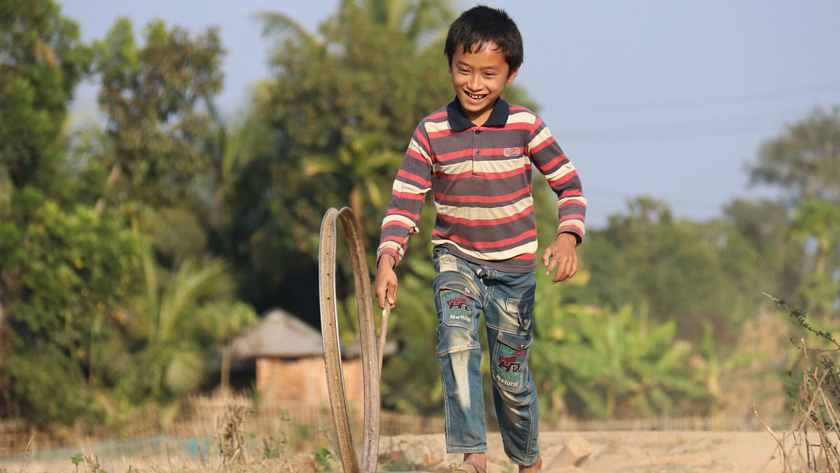 A child playing with a bicycle wheel ring at Dakshin Golabari, Rangamati on 27 January. Photo: Nerob Chowdhury Supriya Chakma