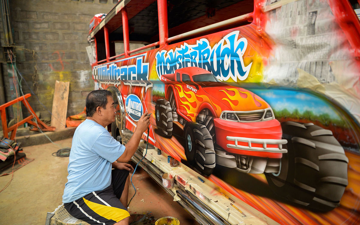 his photo taken on 29 November 2018 shows Vic Capuno, 52-year-old jeepney artist, painting in the side of one of the vehicles at a workshop in San Pablo, Laguna province, south of Manila. Photo: AFP