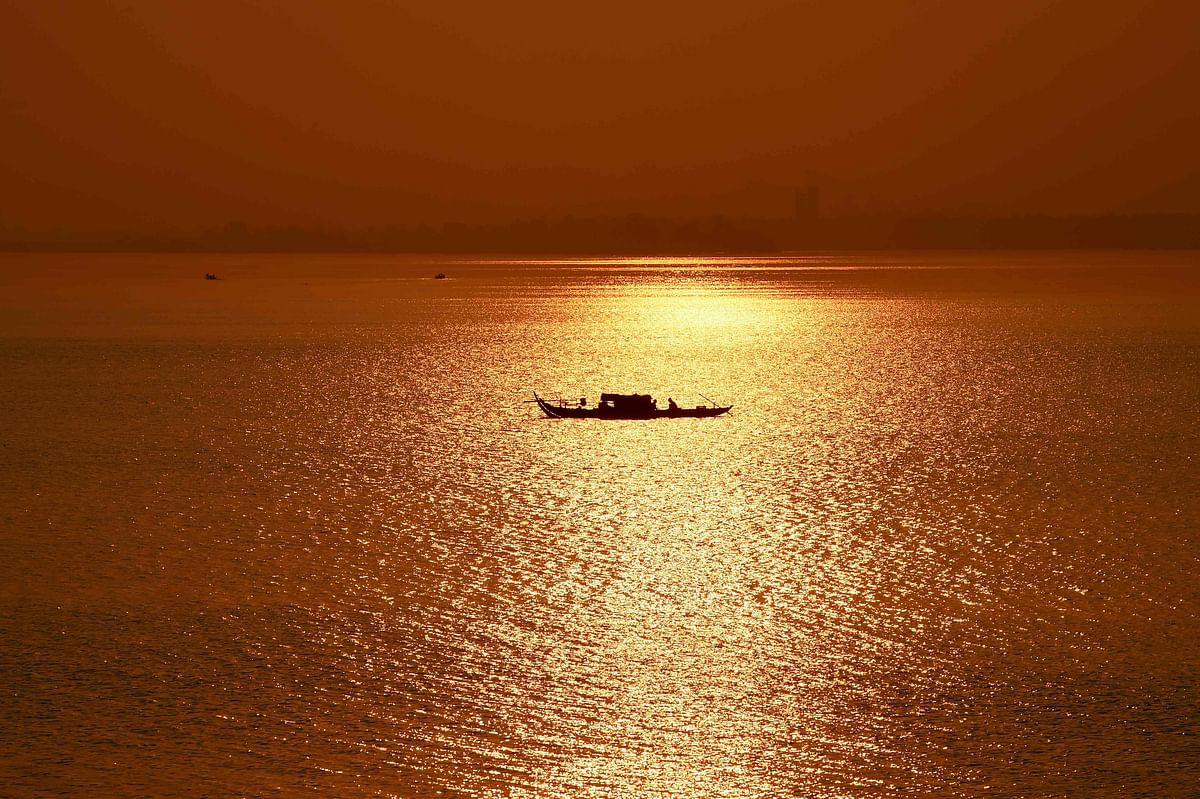 A fishing boat travels along Mekong river as sunrises over Phnom Penh on 29 January 2019. Photo: AFP