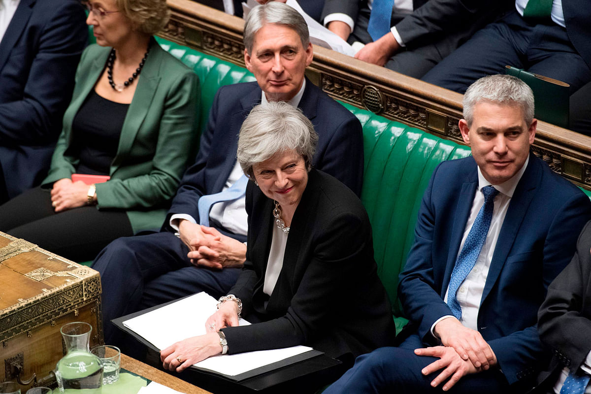 A handout photograph released by the UK parliament shows Britain`s prime minister Theresa May (C) smiling in the House of Commons in London on 29 January 2019, as members of Parliament vote on amendments to Theresa May`s Brexit withdrawal bill. Photo: Reuters