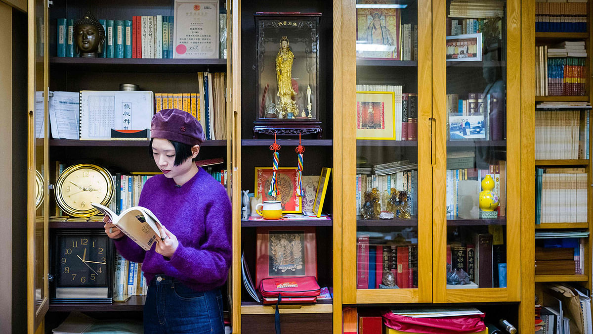 This picture taken on 25 January 2019 shows feng shui master Thierry Chow posing with a book in her office in Hong Kong ahead of the Lunar New Year of the Pig. Photo: AFP