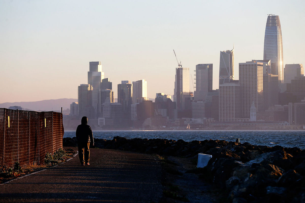 The San Francisco skyline is seen behind a woman as she walks past a condemned area on Treasure Island, near San Francisco, California, US on 18 October 2018. Photo: Reuters