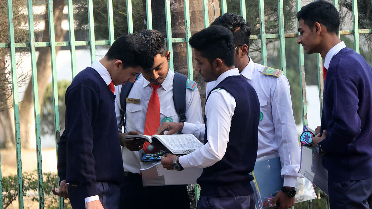 Students taking a last minute look into a book before entering exam halls at Shahid Khokon municipality park in Bogura during the SSC and equivalent exams starting across the country on 2 February. Photo: Soel Rana