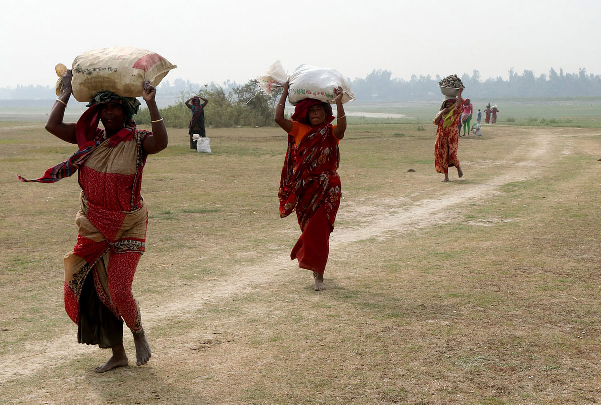 Women carrying soil for making clay stoves at the char areas of river Jamuna at Nayaparachar, Sariakanda in Bogura on 3 Februaty. Photo: Soel Rana