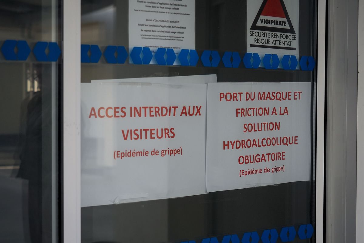 This picture taken on 27 January 2019 shows two signs at the entrance of the retirement home `Les Ombrages` in La Chapelle-Saint-Mesmin, near Orleans, reading `Access Denied to Visitors` and `Mask must be worn at all times and friction with a hydroalcoholic solution is compulsory` as six persons died likely due to a flu-like syndrome in January. Photo: AFP