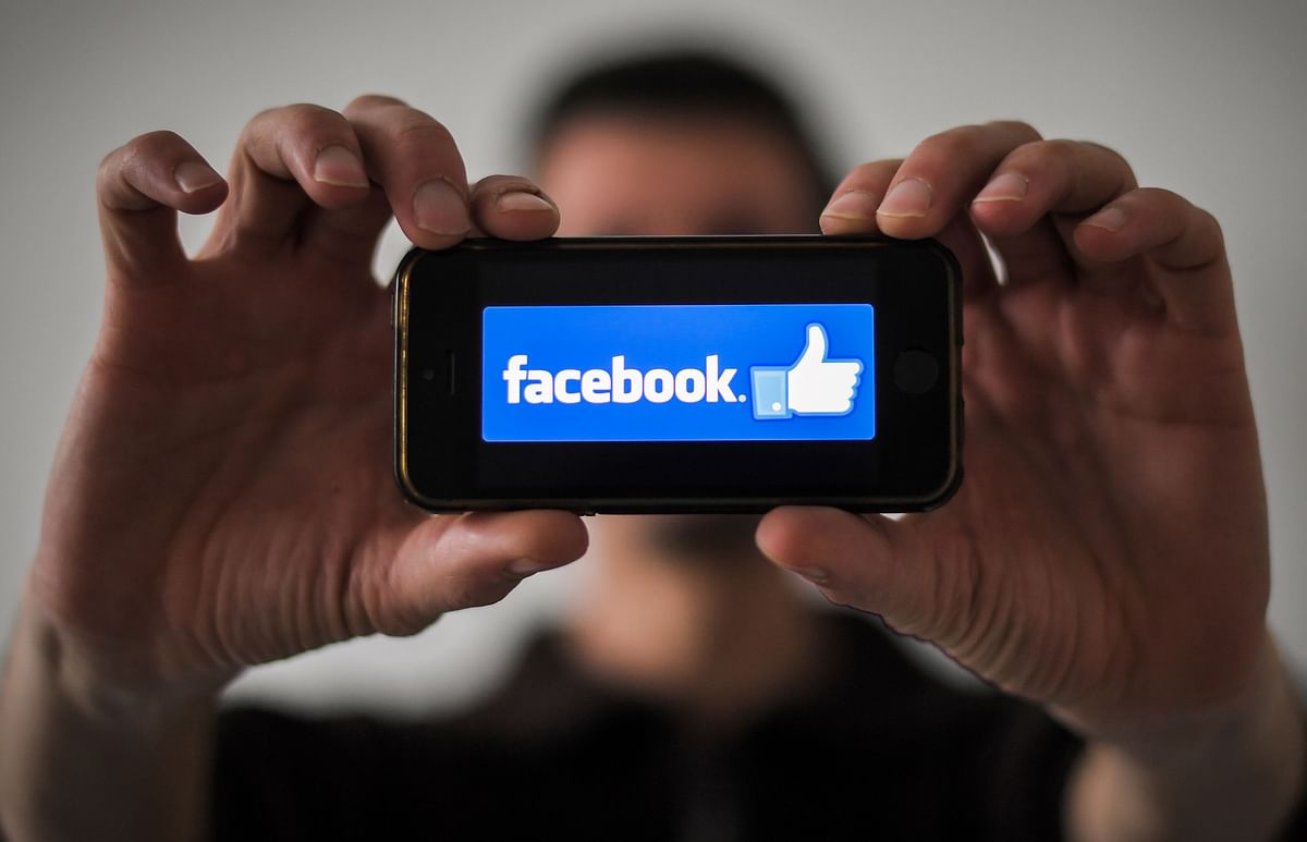 In this file photo taken on 15 January 2019, a man shows the logo of social network Facebook displayed on a smartphone in Nantes, western France. Photo: AFP