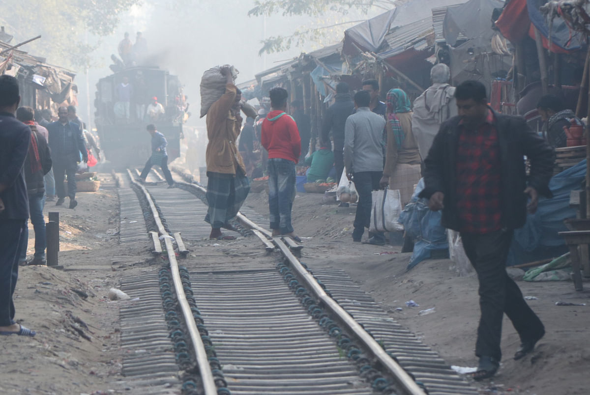 People crossing railway line with a running train just a few metres back at No.3 Railghumti in Bogura on 6 February. Photo: Soel Rana