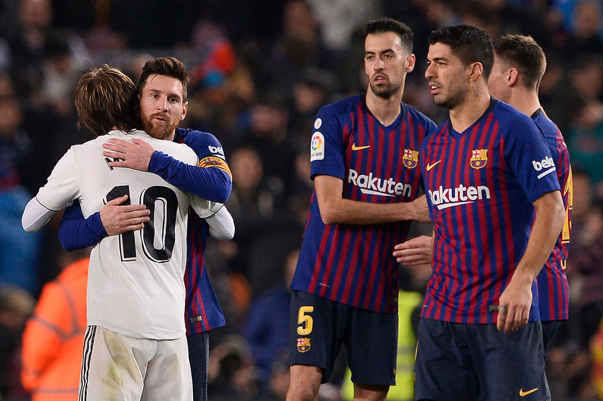 Barcelona`s Argentinian forward Lionel Messi (2L) hugs Real Madrid`s Croatian midfielder Luka Modric at the end of the Spanish Copa del Rey (King`s Cup) semi-final first leg football match between FC Barcelona and Real Madrid CF at the Camp Nou stadium in Barcelona on 6 February 2019. Photo: AFP
